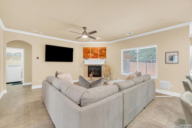 living room with washer / clothes dryer, crown molding, ceiling fan, and light tile patterned flooring