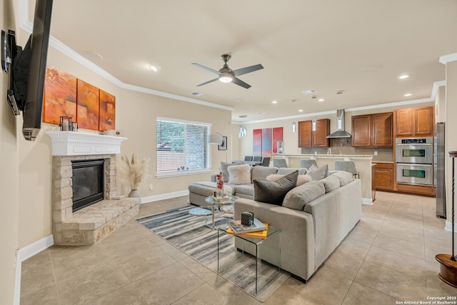 tiled living room featuring ornamental molding, a stone fireplace, and ceiling fan