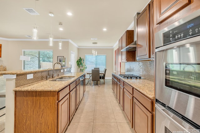 kitchen featuring light tile patterned flooring, pendant lighting, sink, a kitchen island with sink, and crown molding