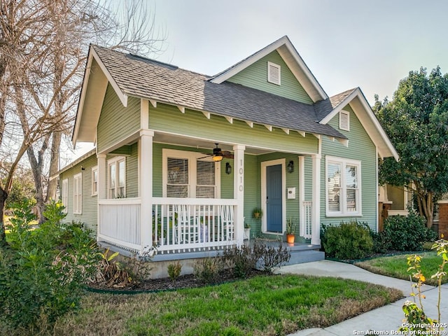 view of front facade with a front yard, ceiling fan, and a porch