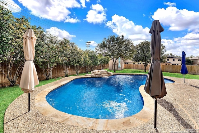 view of swimming pool with a storage shed