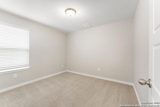 carpeted spare room featuring plenty of natural light