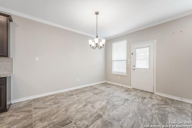 unfurnished dining area featuring crown molding and a notable chandelier