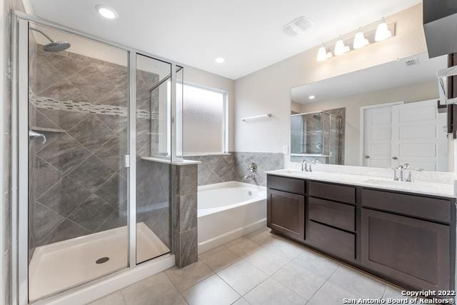 bathroom with tile patterned floors, independent shower and bath, and vanity