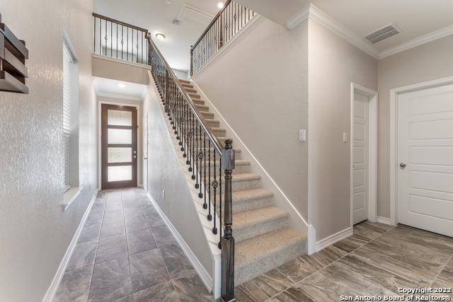 stairs with crown molding and a towering ceiling