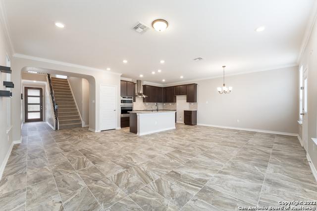 kitchen featuring sink, crown molding, decorative light fixtures, a chandelier, and dark brown cabinets