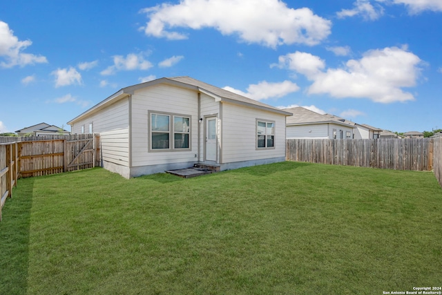 rear view of property with a yard