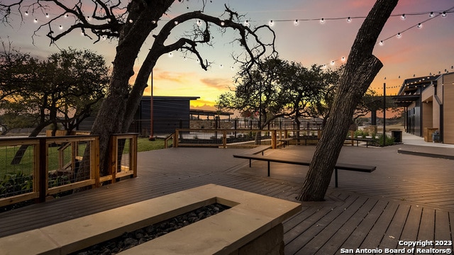 deck at dusk with a fire pit