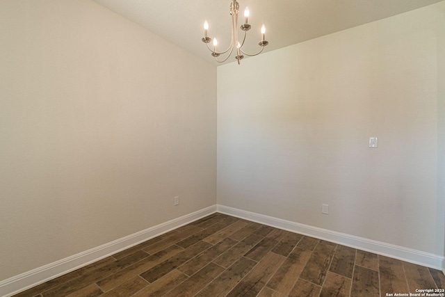 unfurnished room with an inviting chandelier and dark hardwood / wood-style flooring