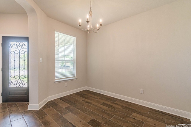 foyer featuring a notable chandelier and dark wood-type flooring