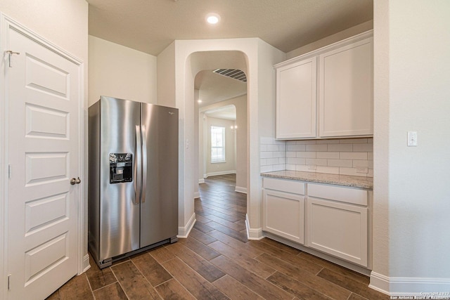 kitchen featuring stainless steel refrigerator with ice dispenser, dark hardwood / wood-style floors, light stone countertops, and white cabinets