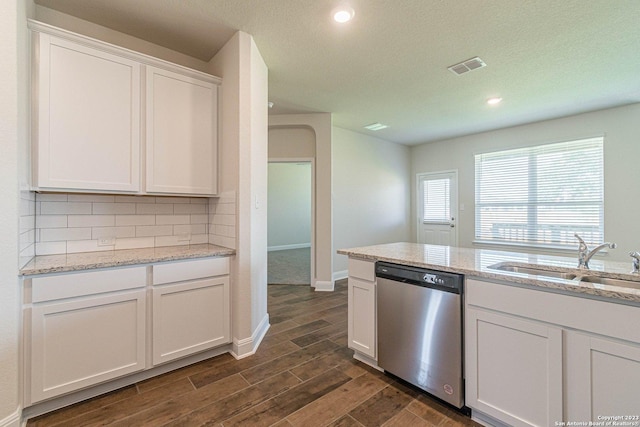 kitchen with dishwasher, sink, light stone countertops, and white cabinets