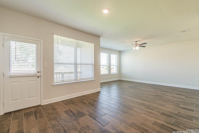 interior space with ceiling fan, dark hardwood / wood-style floors, and a textured ceiling