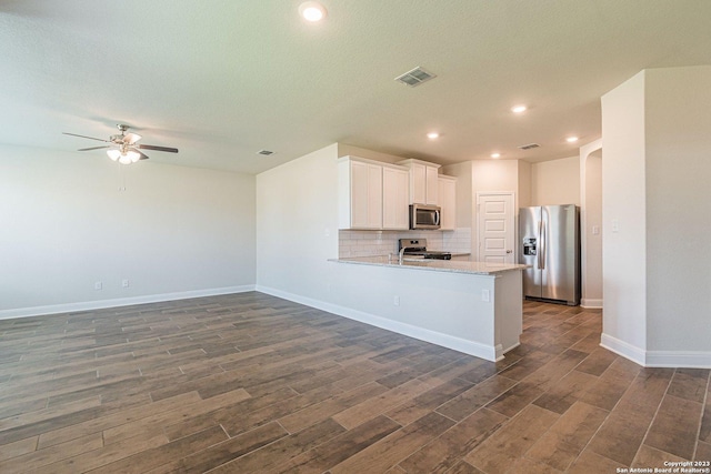 kitchen featuring white cabinetry, stainless steel appliances, dark hardwood / wood-style floors, and kitchen peninsula