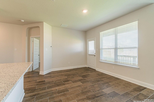 unfurnished dining area featuring a textured ceiling