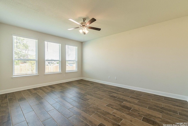 spare room featuring ceiling fan, a wealth of natural light, and dark hardwood / wood-style flooring