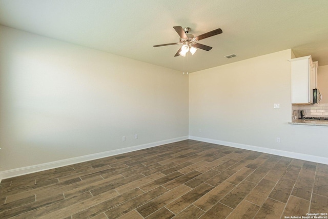 spare room with dark wood-type flooring and ceiling fan