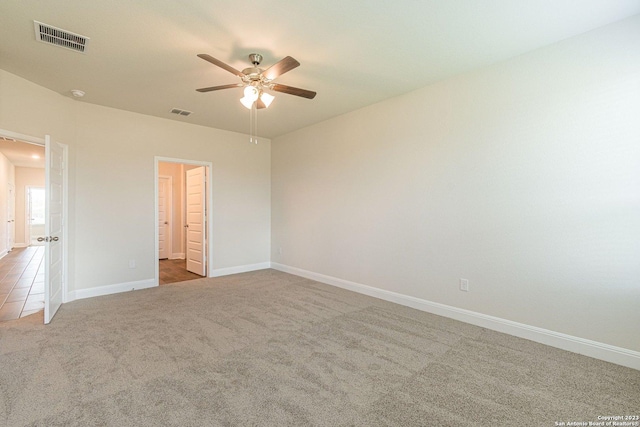 carpeted spare room with ceiling fan