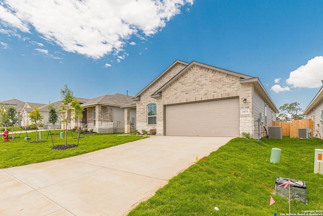 view of front of home with central AC, a garage, and a front yard