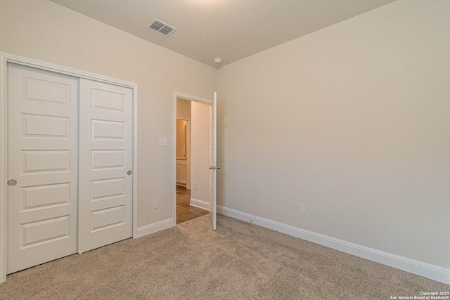 unfurnished bedroom featuring carpet floors and a closet