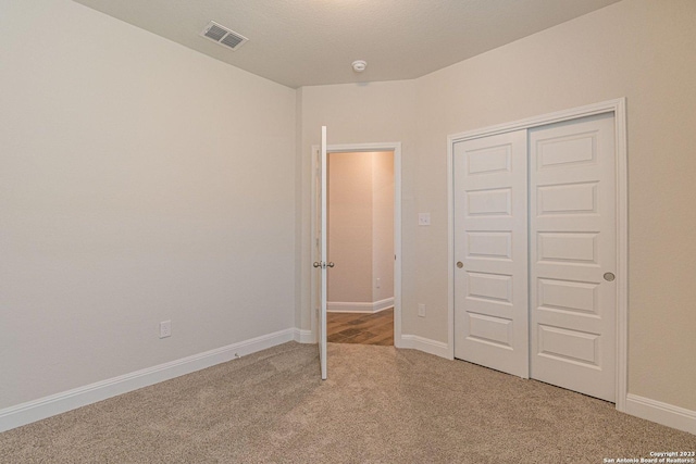 unfurnished bedroom with a closet and carpet flooring