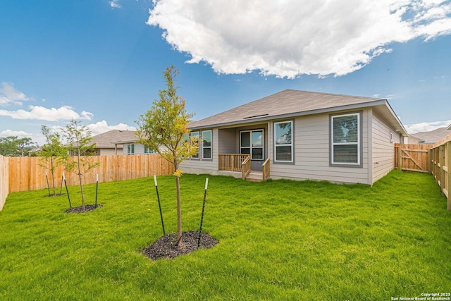 rear view of house featuring a lawn