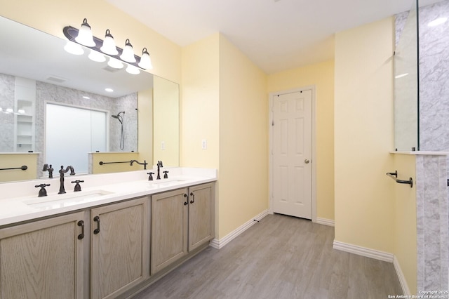 bathroom with walk in shower, vanity, and hardwood / wood-style floors