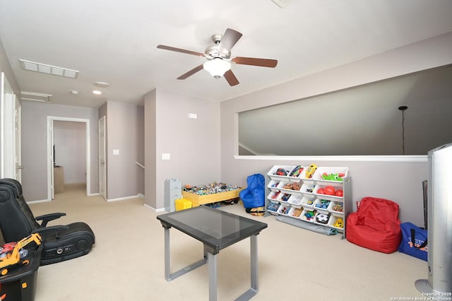 recreation room with ceiling fan and light carpet