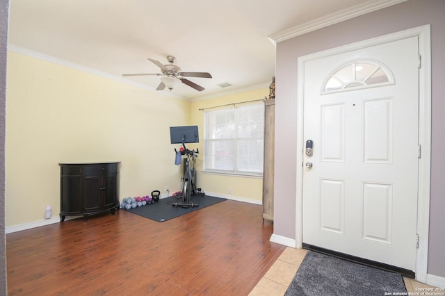 exercise room featuring crown molding, wood-type flooring, and ceiling fan