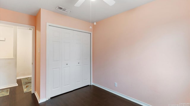 unfurnished bedroom with a closet, dark hardwood / wood-style floors, and ceiling fan