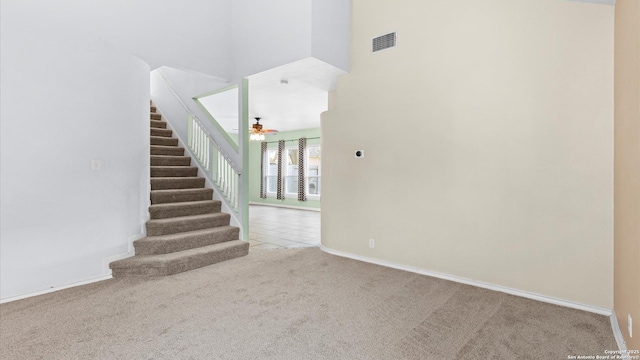 stairs featuring a high ceiling and carpet flooring