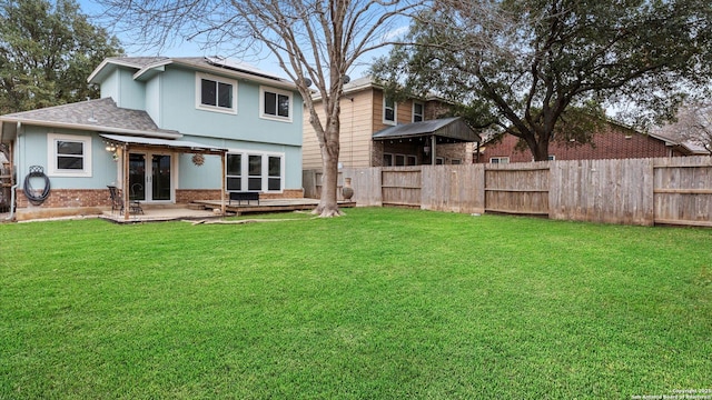 rear view of property featuring a patio and a lawn