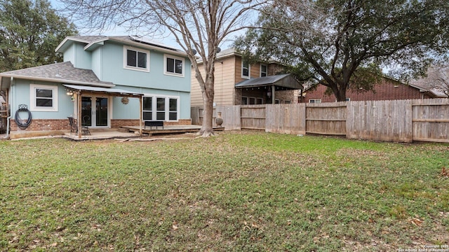 back of house featuring a patio and a lawn