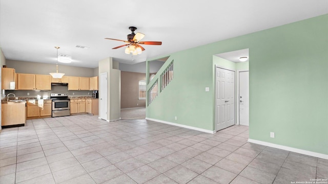 kitchen with sink, ceiling fan, stainless steel range with electric stovetop, hanging light fixtures, and light brown cabinets