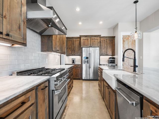 kitchen featuring sink, light stone countertops, wall chimney exhaust hood, and high quality appliances