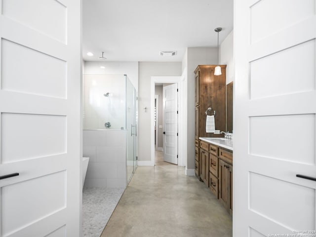 bathroom with concrete flooring, vanity, and a shower with shower door