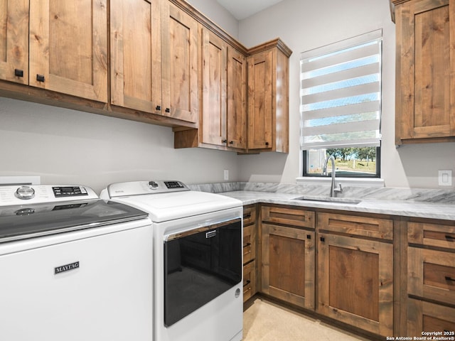 washroom featuring cabinets, sink, and washer and dryer