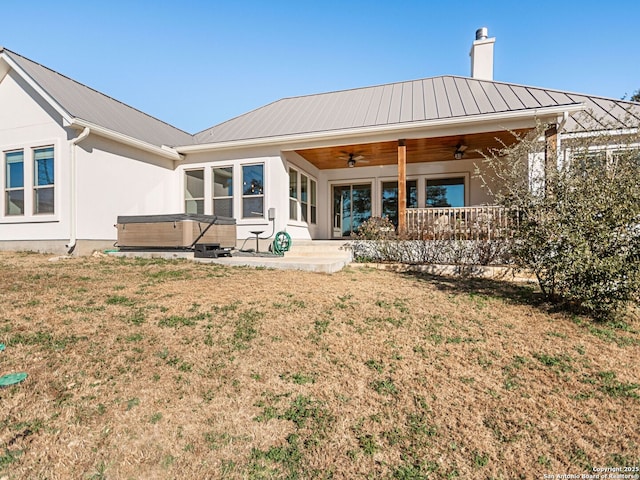 back of house featuring a lawn, ceiling fan, a patio area, a hot tub, and covered porch