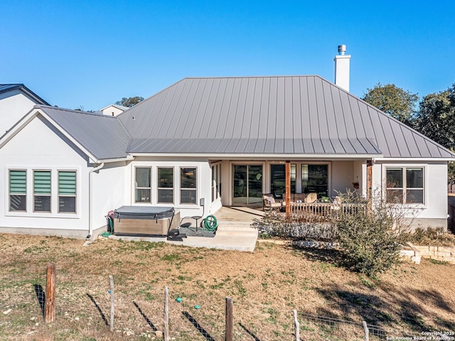 back of house featuring a hot tub and a patio area