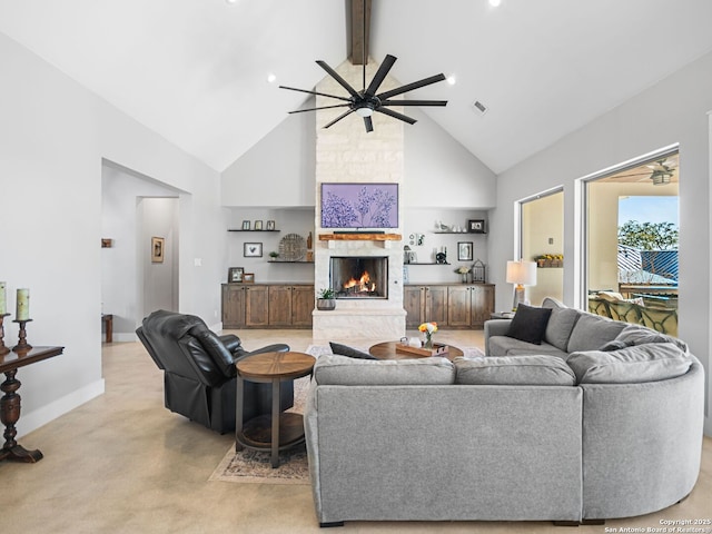 carpeted living room with beamed ceiling, ceiling fan, a stone fireplace, and high vaulted ceiling