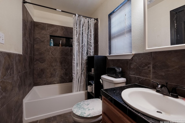 full bathroom with shower / bathtub combination with curtain, tile walls, vanity, tile patterned floors, and toilet