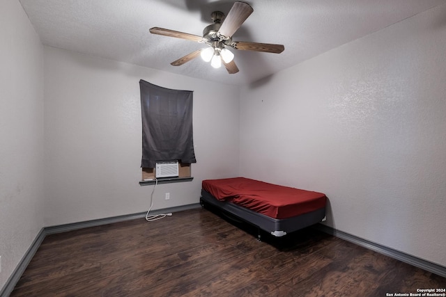 bedroom featuring ceiling fan, dark hardwood / wood-style floors, cooling unit, and a textured ceiling