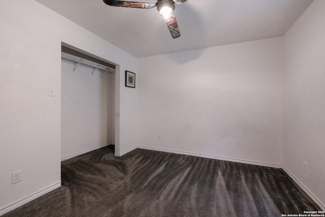 unfurnished bedroom featuring ceiling fan, dark carpet, and a closet