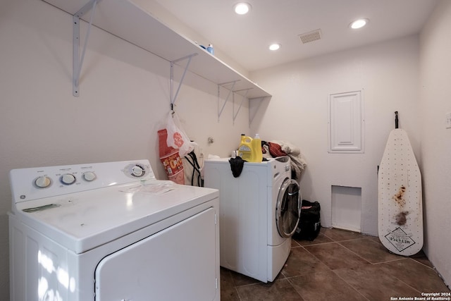 laundry room featuring independent washer and dryer and dark tile patterned flooring