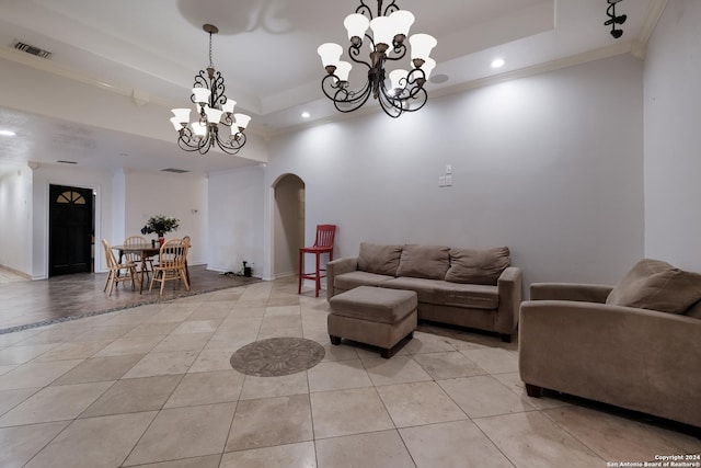 tiled living room featuring an inviting chandelier, ornamental molding, and a raised ceiling