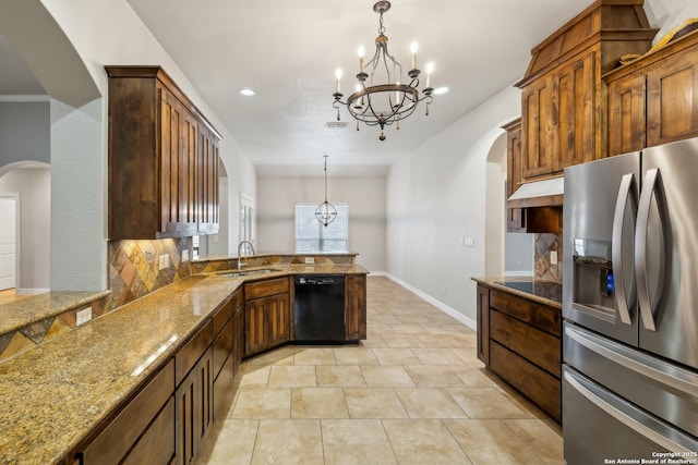 kitchen featuring sink, decorative light fixtures, light stone countertops, decorative backsplash, and black appliances