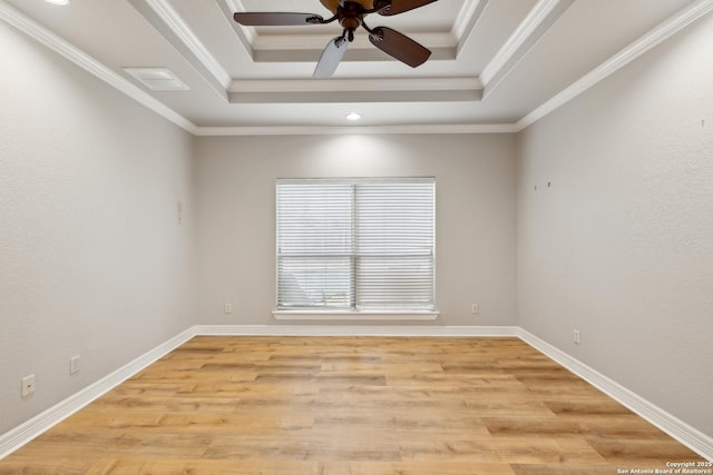 spare room with crown molding, light hardwood / wood-style floors, a raised ceiling, and ceiling fan