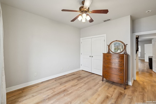 unfurnished bedroom with ceiling fan, light hardwood / wood-style floors, and a closet