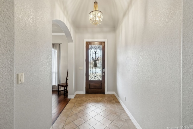 tiled entryway featuring a chandelier