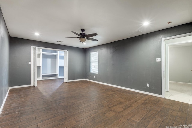 unfurnished room featuring dark wood-type flooring and ceiling fan